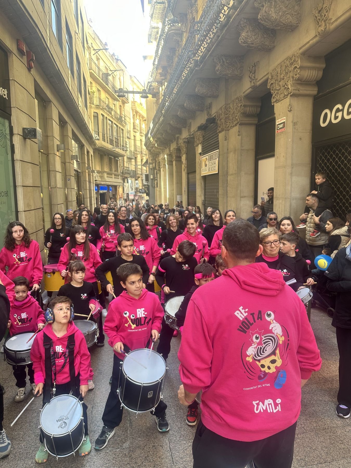 Grup infantil de batucada desfilant per un carrer amb La Batubanda