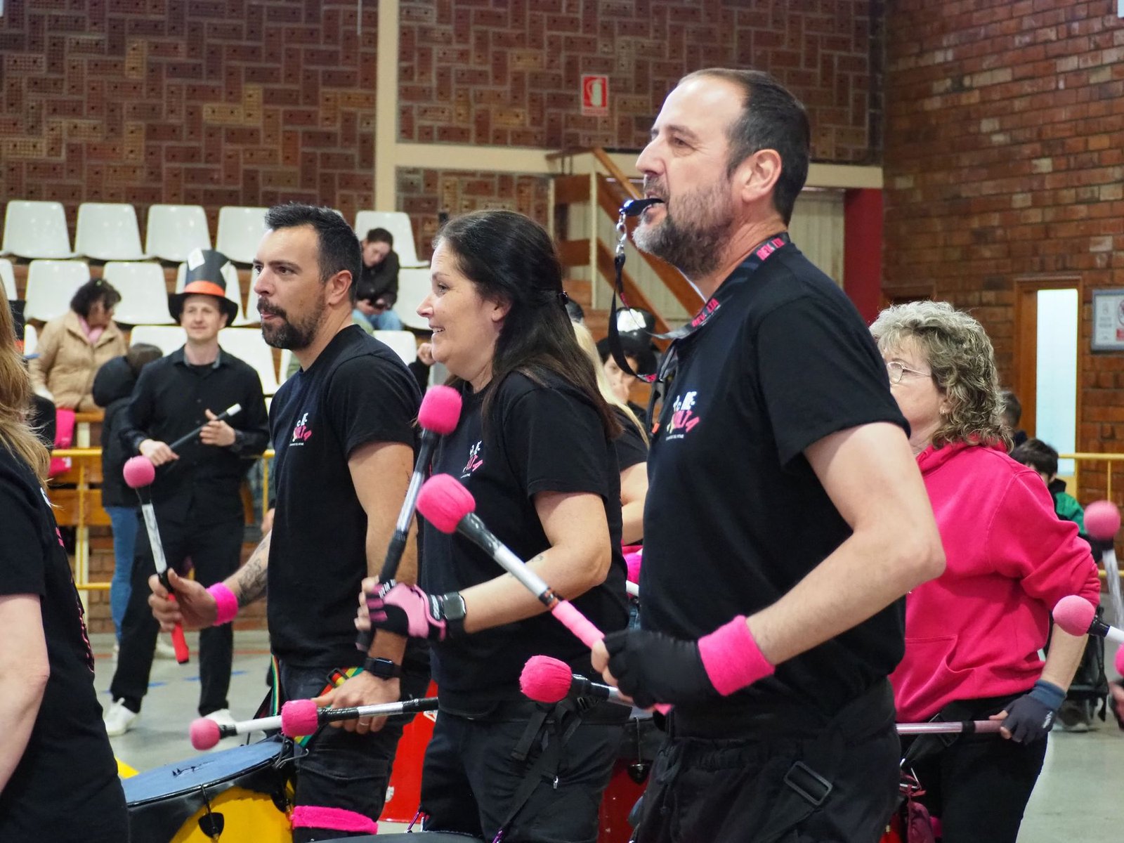 Grup d'adults tocant percussió junts en una sala durant un team building